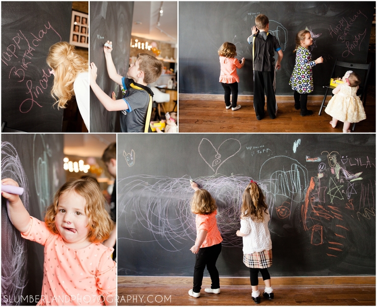Party guests drawing on chalkboard wall at Heritage Littles